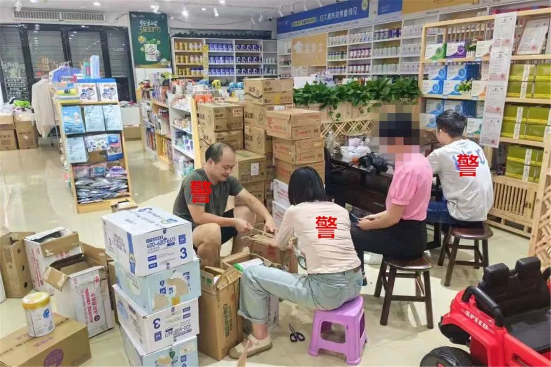 ▲民警在清点奶粉等涉案货物